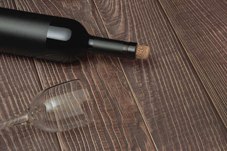 Wine glass and collectible bottle of wine on wooden background with old textureの写真素材