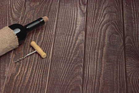 Wine bottle with vintage label and corkscrew on wooden table top backgroundの写真素材