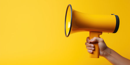 Generative AI, megaphone in hand on an empty yellow background, panoramic image with copy spaceの素材