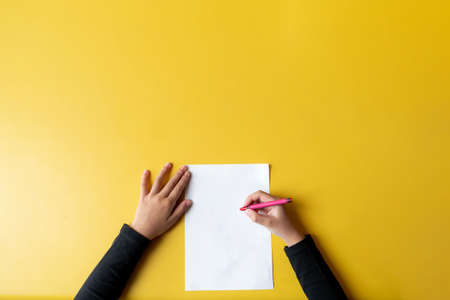 a child draws on the yellow table. Top viewの写真素材