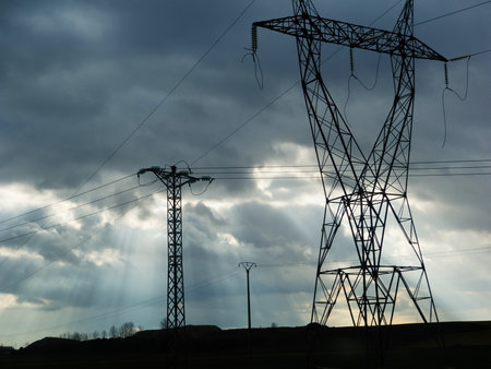 Cloudscape with High voltage power lines and sunbeamsの写真素材