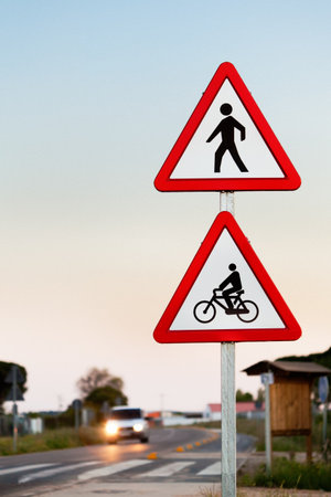 Pedestrian and Cycling Crossing Sign with car lights in background. Selective focus.の写真素材