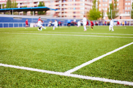 Limit lines of a sports grass field with defocused football playersの写真素材