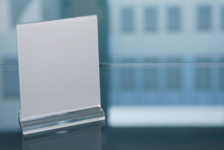 Plexiglass information board on glasstable with reflection of a business building.の写真素材