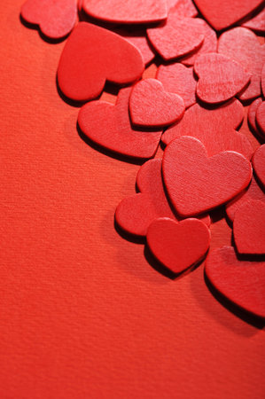 many small red wood hearts on red background