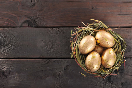 Golden eggs in nest on old weathered wooden boardの写真素材