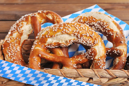 Three original Bavarian salted pretzels soft in front of wooden board