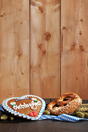 Bavarian Oktoberfest pretzel soft with gingerbread heart hops, and wheat from Germany on old beer barrelの写真素材