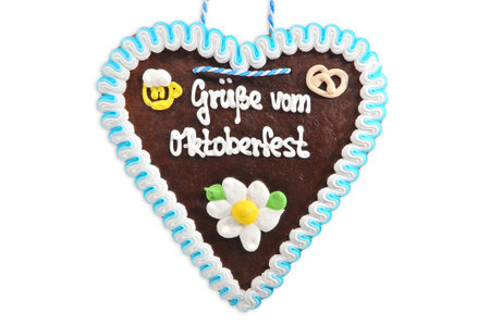Regards from the Oktoberfest - original Bavarian Oktoberfest gingerbread heart from Germany on white backgroundの写真素材