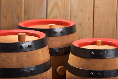Three old beer barrels with plugs on wooden board