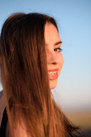 Portrait of pretty girl at sunset, smiling and with loose hairの写真素材