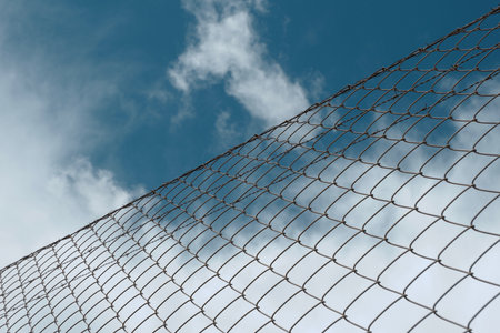 Edge of metallic net under vivid blue sky. Concept of change and safety. Community of Madrid, Spainの写真素材