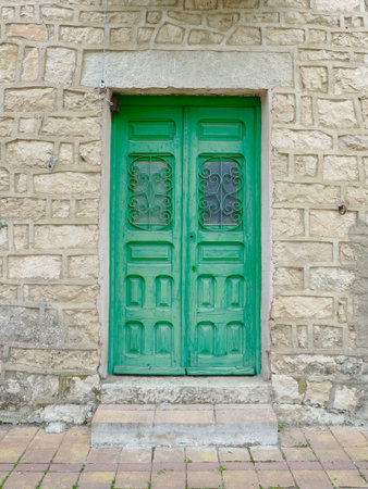 Green wooden door in Patones village, Community of Madrid. Vintage doorway in rural area of Spainの写真素材