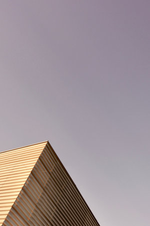 Vertical minimal urban background. Look up to the corner of modern building with clear guided lines.の写真素材
