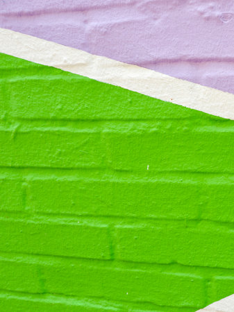 Lined painted by vivid green and violet colours brick wallの写真素材
