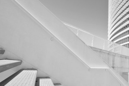 Black and white minimal architectural forms with staircase and fence. Artistic composition of elements. Buildings from outsideの写真素材