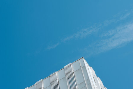 Minimal background with falling corner of white building against the blue sky with cloud