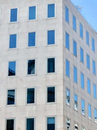 Corner of minimal building facade with simple glass windows. Vertical photoの写真素材