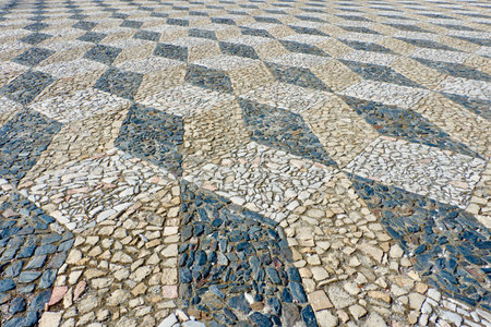 Lined stone flooring outside in the downtown square in Elvas, Alto Alentejo, Portugal. Elegant ornament made of rough stones of black, beige and white coloursの写真素材