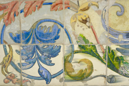 Vintage faded tiles with floral ornate. Damaged, weathered tiled wall. Heritage concept of traditional Spanish art.の写真素材