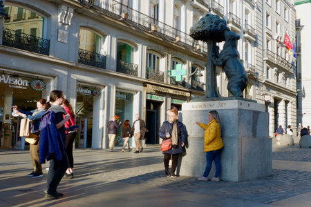 Madrid, Spain - February 18, 2022: people make photos in front of the statue of a bear, symbol of the city.のeditorial素材