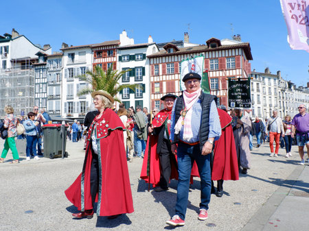 Bayonne, France, April 17, 2022: group of elder people in basque costumes walking on the street during local food festival.のeditorial素材