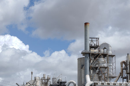 Pipe of the cement factory against moody sky. Production site, industrial workspace. Backdrop with copy space.の写真素材