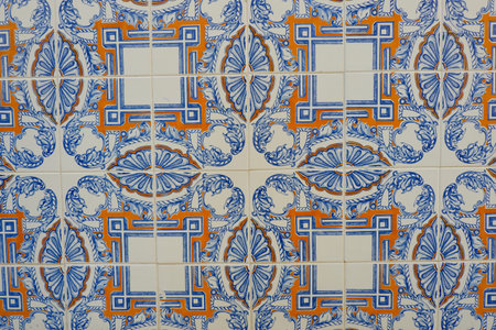 Old vintage tiles of blue and orange geometrical ornate on the wall downtown Lisbon, Portugal.