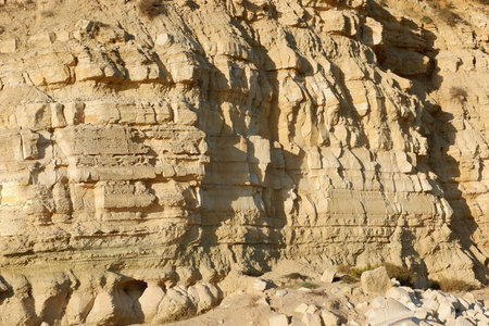 Surface of cliff rock of warm colour at seaside of Algarve in Portugal. Textured backdrop.の写真素材