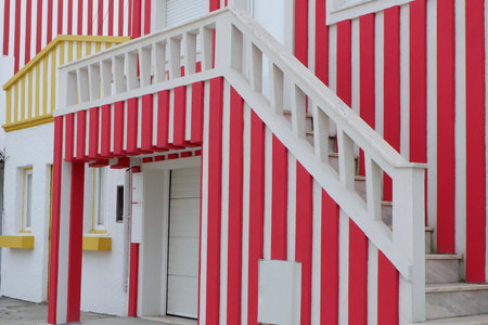 Lined facades of beach houses of vivid red and yellow colours in Aveiro, Portugal.の写真素材