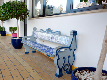 Authentic bench decorated with ceramic tiles of blue and white color outside in the shade of the yard in Carvoeiro, Portugal.の写真素材
