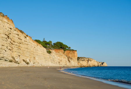 Calm oceanic beach of vivid colors lighted by golden sunset in coast of Lagos, Portugal.の写真素材