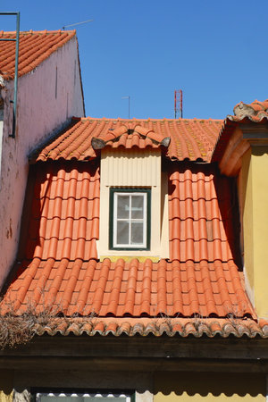 Vintage tiled roof with tiny window of authentic Portuguese building downtown Lisbon, Portugal.の写真素材