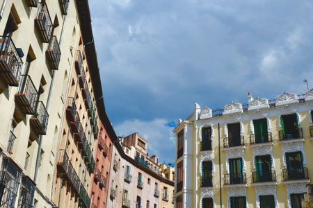 Upward view on vintage facades under dramatic gray sky downtown Madrid, Spain.の写真素材