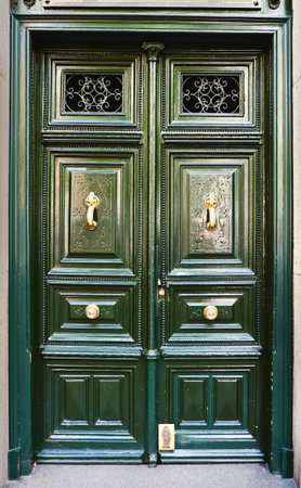 Antique classical door of dark green color with rich ornamental details downtown Madrid, Spain....