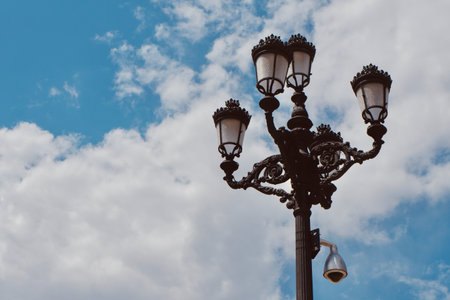 Vintage historical street lamp against moody skyline at daytime downtown Madrid, Spain.の写真素材