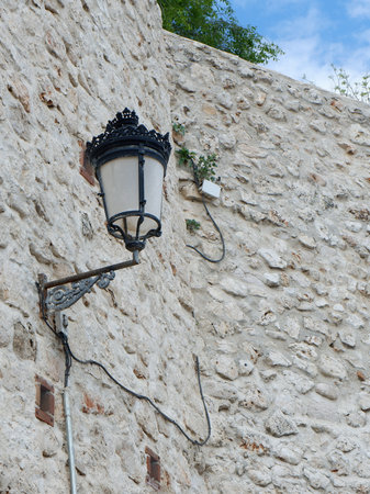 Vintage street lamp on the antique stone wall in the village in Spain.の写真素材