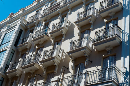 Historic building features intricate balconies with ornate railings. The architecture showcases classic European style with a bright blue sky as the backdrop, creating a vibrant atmosphere.の写真素材
