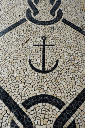 A detailed mosaic floor showcases an anchor symbol, surrounded by intricate patterns. The setting reflects a maritime theme, capturing the coastal spirit in natural light.の写真素材