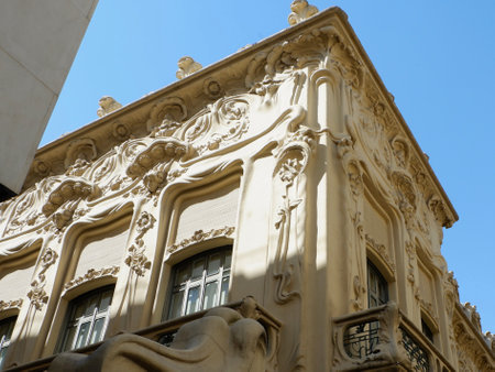 Wonders of early 20th-century architecture are displayed in this historic building featuring detailed carvings and unique design. Sunlight illuminates the ornate facade highlighting its beauty.の写真素材