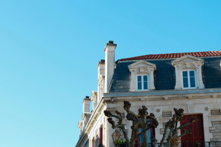 Bright sunshine illuminates the elegant facade of a historical building, showcasing its intricate...