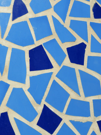 A collection of mosaic tiles in various shades of blue forms a beautiful pattern on the ground. The sunny afternoon light enhances the colors, showcasing artistry and design.の写真素材