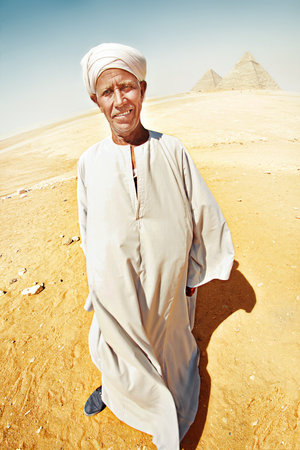 smiling bedouin full-length with a white arafat knotted on his headのeditorial素材