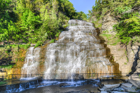 Hector falls in New York surrounded by trees and plants. A beautiful roadside waterfall just north...