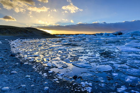 View of the glacier lagoon, Jokulsarlon, Iceland at sunset. Jokulsarlon is a large glacial lake in...