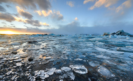 View of the glacier lagoon, Jokulsarlon, Iceland at sunset. Jokulsarlon is a large glacial lake in...