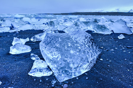 View of the glacier lagoon, Jokulsarlon, Iceland on the beach as it meets the Atlantic Ocean ...