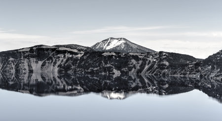 Clear blue water of Crater Lake National Park in Oregon during early spring with some snow left from winter. Wizard Island in the distance.の写真素材