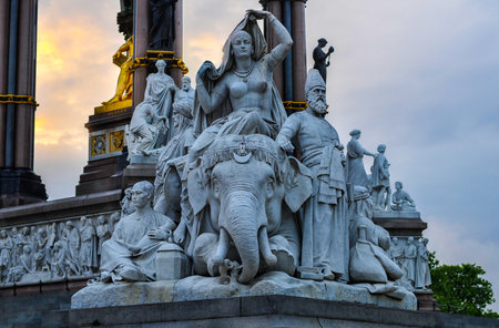 Statue along the  corner of the Prince Albert Monument in Hyde Park contrasting the neo-gothic monument against a threatening sky.のeditorial素材