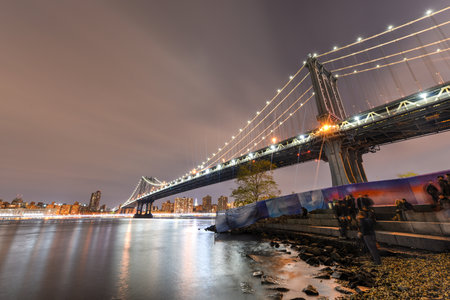 BROOKLYN, NEW YORK - NOVEMBER 8, 2014: Brooklyn Bridge at night viewed from the Brooklyn Bridge Park in New York City.のeditorial素材
